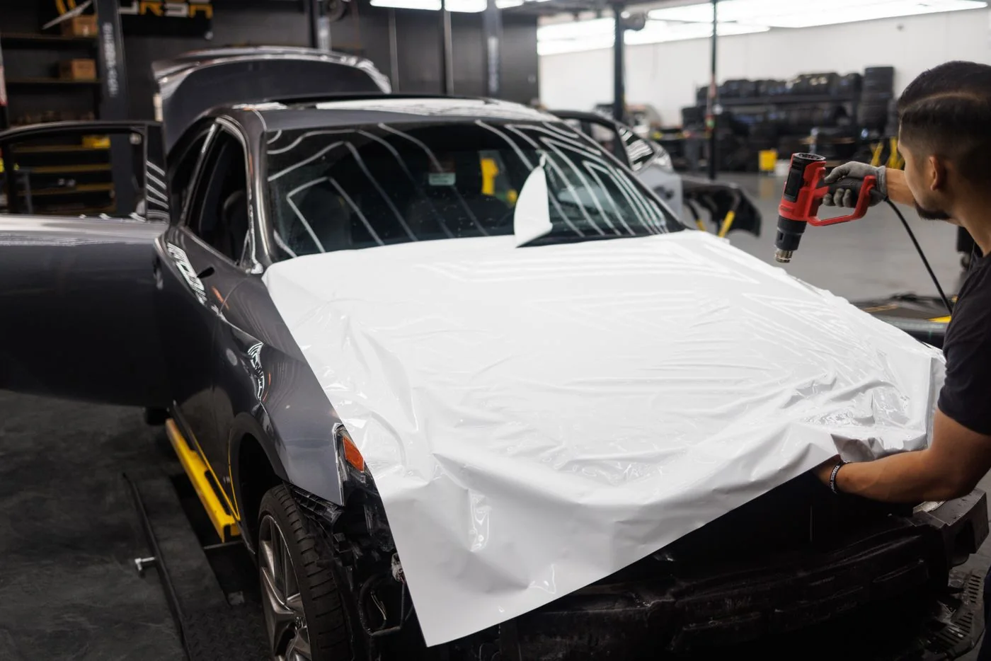 Een monteur werkt aan wrapfolie op een auto